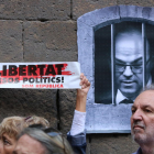 Un cartell demana la llibertat dels «presos polítics» amb una imatge del conseller destituït Jordi Turull al costat, a la plaça del Rei de Barcelona.