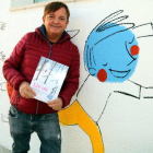 L'il·lustrador Ignasi Blanch amb un exemplar del llibre-disc 'LIV ON' al costat dels seus dibuixos al pati de l'escola de Xerta.