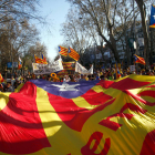 Imagen de la estelada, en primer término, y los manifestantes en Madrid con carteles y banderas.