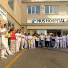 Una cuarentena de trabajadores del Pius Hospital de Valls leyendo un manifiesto de protesta delante del centro.