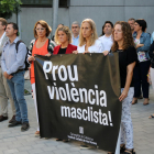 Personas concentradas y la pancarta desplegada durante el minuto de silencio para recordar a la mujer muerta en manos de su hijo en Tortosa.