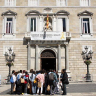 La fachada del Palau de la Generalitat con la pancarta restablecida y un grupo de personas mirando la fachada este 27 de mayo.