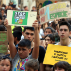 Pla mitjà d'un nen i un noi mostrant cartells contra el canvi climàtic a la plaça de la Font de Tarragona, el 27 de setembre del 2019