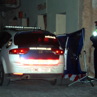 Un vehículo de los Mosso D'Esquadra y un agente custodiando la entrada en la casa donde se ha producido el incendio mortal en Arnes.