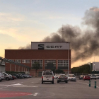 Imagen de la fachada frontal de la fábrica Seat con humo en segundo término proveniente de un incendio en el Museo Histórico.