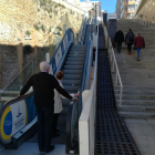 Dues persones dubten a pujar per les escales espatllades i altres tres fan el tram afectat a peu.