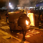 Un manifestant davant d'un contenidor cremant a la Travessera de les Corts, davant l'accés 18 al Camp Nou.