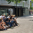 Imagen de unos adolesccents con el móvil en la calle.