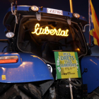 Plano corto de un tractor que lleva un panel luminoso con la palabra 'libertad'.
