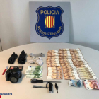 Imagen de los objetos y el dinero intervenido a los autores del robo en el interior de un vehículo.
