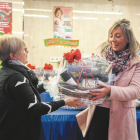 Una cliente –derecha– recibe la cesta ganadora del sorteo de la Navidad pasada en el mercado de Torreforta.