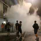 Un grup de manifestants a l'aeroport del Prat convocats per Tsunami Democràtic, enmig de fum.