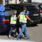Dos agents de la policia espanyola traslladant un dels detinguts pel lloguer fraudulent d'apartaments turístics.