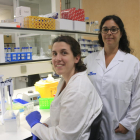 La doctora María José Buzón, del Grup de Malalties Infeccioses del Vall d'Hebron Institut de Recerca (VHIR) (dreta), amb una altra investigadora de l'equip, Laura Luque (asseguda), al laboratori.