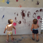 Dos infants pintant en una paret a la llar d'infants del Morell.