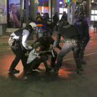 Pla general dels Mossos d'Esquadra detenint un manifestant durant la quarta nit d'aldarulls a Tarragona.