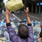 Un hombre lanza una bolsa de basura en torno a la delegación del gobierno español en Barcelona.