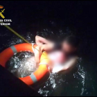 Agentes de la Guardia Civil tirando un salvavidas al hombre que estaba en el agua.