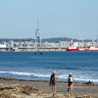 Dos motos acuáticas y una lancha haciendo busca de desaparecidos al mar, entre el puerto de Tarragona y la playa del Pinar, llena de cañas y con dos personas señalando al horizonte.