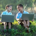 Dos nens amb un ordinador.