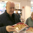 Un cliente de la pastelería Peralta de Tortosa con una bandeja de panellets.