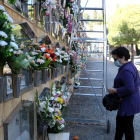 Pla general d'una dona portant les flors a una sepultura al cementiri de Tarragona en la festivitat de Tots Sants