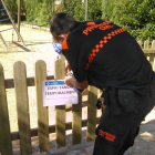 Imagen de un técnico de Protección Civil retirando los carteles de cierre temporal.
