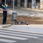 Un agent de la Guàrdia Urbana observant la bicicleta accidentada.