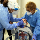 Imagen de archivo de dos enfermeras haciendo un test|tiesto rápido de antígenos a un niño.