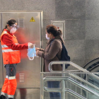 Una voluntària de la Creu Roja entregant una mascareta a l'estació de metro Diagonal de Barcelona