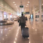 Un viatger caminant amb maletes a la zona d'arribades de la T1 a l'aeroport del Prat el 19 de juny del 2020.
