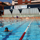 Dues dones nedant a la piscina exterior de 50 metres del Club Natació Reus Ploms.
