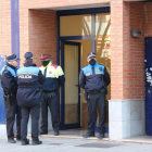 Agentes de la Policía Local de Esplugues de Llobregat y de los Mossos d'Esquadra, en la puerta del edificio donde está el domicilio del detenido.