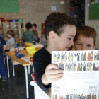 Unos niños mirando un libro de gigantes en la escuela Corazón|Coro de Roble de Santa Coloma de Queralt.