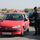 Una gent de l'ARRO dels Mossos d'Esquadra demanant tornant a un conductor un certificat d'autoresponsabilitat, durant un control a l'antiga N-II, al terme municipal d'Alcarràs