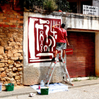 Un artista treballant en una de les creacions del festival Riu d'Art de Riba-roja d'Ebre.