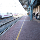 La estación de l'Aldea-Tortosa-Amposta, con viajeros en el andén mientras un tren rápido pasa de largo sin hacer parada|puesto.
