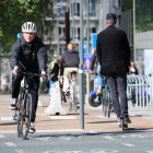 Un ciclista i un noi en patinet circulant pel centre de Brussel·les durant la primera setmana de desconfinament
