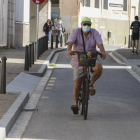 Una persona circula en bicicleta, con la mascarilla puesta, por el centro de Reus.
