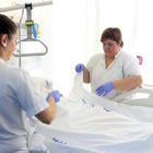 Imatge d'arxiu de dues infermeres amb un pacient.