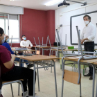 Un profesor de l'IES Joanot Martorell hablando con varios alumnos de segundo de bachillerato en un aula del centro.