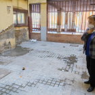 Camacho, presidenta de la comunidad, observando con resignación el mal estado del patio interior de su edificio, propiedad del AHC.