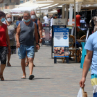 Pla general de persones passejant amb mascaretes per la zona marítima de Calafell Platja.