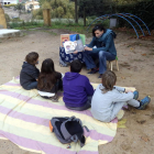 Un grup d'escolars fent classe a un parc infantil públic.