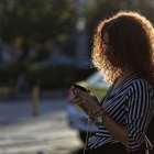 Una dona utilitzant el móbil al carrer.