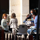 Una família asseguts a la terrassa d'un bar a Tortosa on els serveixen l'esmorzar.
