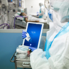 Una de las enfermeras limpia a fondo la tableta para evitar una propagación del virus a través del aparato.