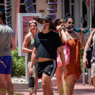 Persones usant mascareteres passegen, el 3 de juliol del 2020, en el passeig turístic de Ocean Drive a Miami Beach, Florida.