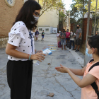 Una docent pren la temperatura i aplica gel a una alumna de l'Escola Prat de la Riba de Reus.