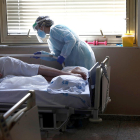 Una sanitaria atendiendo a un paciente en un hospital.